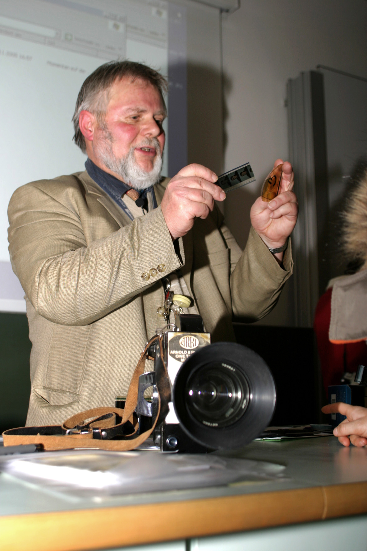 Klaus-Peter Heim während eines Vortrags an der Hochschule mit analogem Filmmaterial sowie einer alten Kamera.