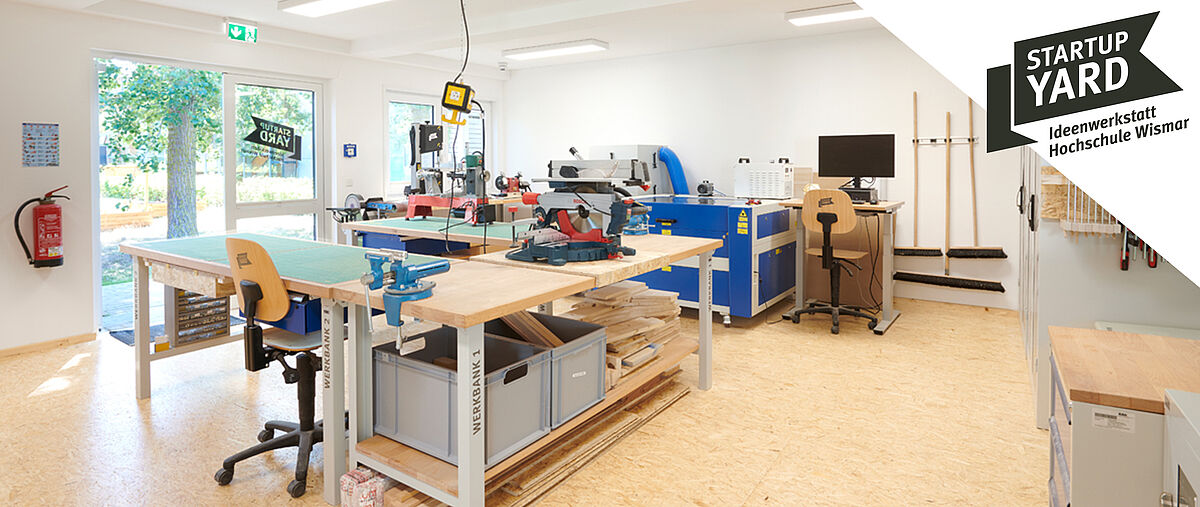 StartupYard Ideenwerkstatt Hochschule Wismar. Lichtdurchfluteter Raum mit Werkbänken, Kreissäge und anderem Werkzeug