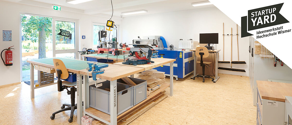 StartupYard Ideenwerkstatt Hochschule Wismar. Lichtdurchfluteter Raum mit Werkbänken, Kreissäge und anderem Werkzeug