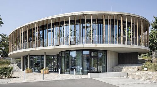Das Foto zeigt die Umweltstation der Stadt Würzburg, gebaut aus Recycling-Beton, mit Sicht auf den Eingang. 