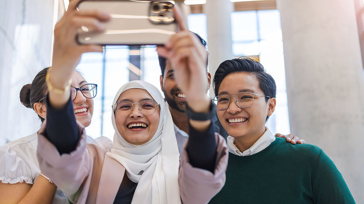 Introduction_Image_Symbolbild_IM_Master_SL_2023 Introduction_Image Studiengang IM Master Drei International Students nehmen ein Selfie auf