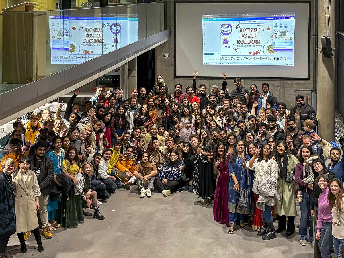 Es sind viele Menschen zu sehen, die dicht zusammenstehen und winken und lachen. Das Bild ist aus ca. fünf meter Höhe aus der 1. Etage aufgenommen worden.