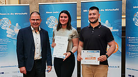 Die beiden Studierenden aus der Hochschule Wismar, Rebecca Zube und Paul Winter präsentieren stolz ihre Gewinnerurkunde. Neben Ihnen steht der Juror Stefan Suckow.