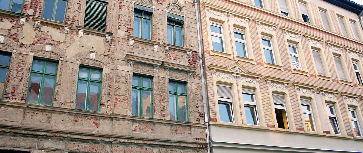 Hauswand: Links ein unsanierter Altbau, recht ein sanierter Altbau