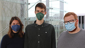 Es sind die drei Ausgezeichneten mit Maske zu sehen.