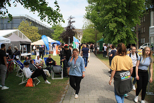 Viele Menschen laufen auf der Campuswiese zwischen den Veranstaltungszelten.