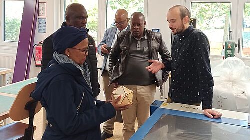 Vier Personen aus Botswana sind in der StartUpYard mit Enrico Kahl am 3D-Drucker zu sehen.