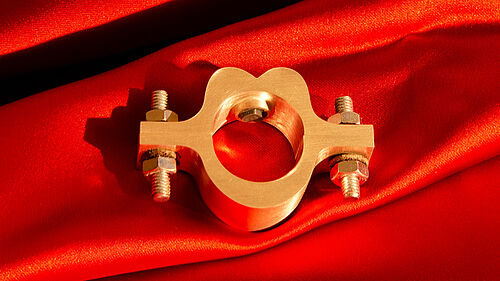 Ein goldfarbener Ring liegt auf einem rotem Tuch.
