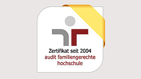 im Bild zu sehen: Logo des Zertifikates audit familiengerechte Hochschule  mit goldenem Band