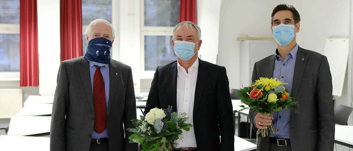 Im Bild ist der Hochschulrat der Hochschule Wismar mit Blumensträußen und Maske zu sehen.