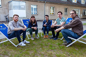 Die fünf Teilnehmenden des ersten KickStart-Ideenwettbewerbs sitzen zusammen in Liegestühlen vor der StartUpYard.
