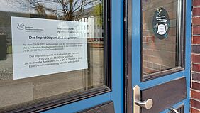 Ein Schild an der Tür des Hauses 18 weist darauf hin, dass der Impfstützpunkt Nordwestmecklenburg in das Wismarer Gesundheitszentrum umgezogen ist.