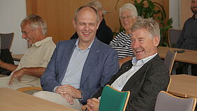 Prof. Dr.-Ing. Axel Rafoth und Prof. Dr.-Ing. Jürgen Siegl, Leiter des Bereiches Seefahrt, Anlagentechnik und Logistik zeigen sich wähend der Feierstunde in guter Stimmung und lachen gemeinsam..