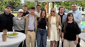 Studierende präsentieren Projektergebnisse Eine Gruppe Studierender steht zusammen mit Prof. Dr. Jantina Nord unter einem Pavillon vor der Hochschulwiese.