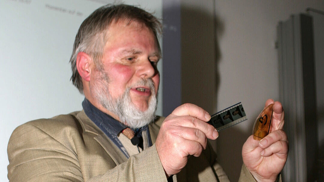 Klaus-Peter Heim während eines Vortrags an der Hochschule mit analogem Filmmaterial sowie einer alten Kamera.
