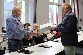 Der Rektor, Prof. Dr. Bodo Wiegand-Hoffmeister, überreicht einem Alumnus der Seminargruppe M68c die Jubiläumsurkunde.