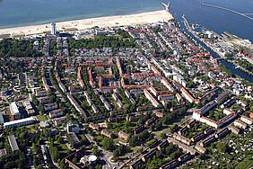 es ist Warnemünde aus dem Flugzeug heraus zu sehen mit dem Campus am unteren Bildrand