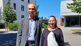 Es sind Prof. Dr. Daniela Schwerdt als neu gewählte Prorektorin für Forschung und Prof. Dr. Michael Schleicher als wiedergewählter Prorektor für Bildung auf dem Campus vor Haus 6 zu sehen.  