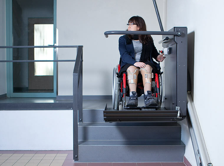 im Bild: Studentin mit Rollstuhl in einem der Schrägaufzüge, die sich mit EU-Schlüsseln bedienen lassen.